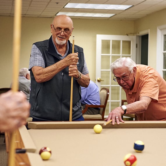 Seniors residents playing pool in senior community